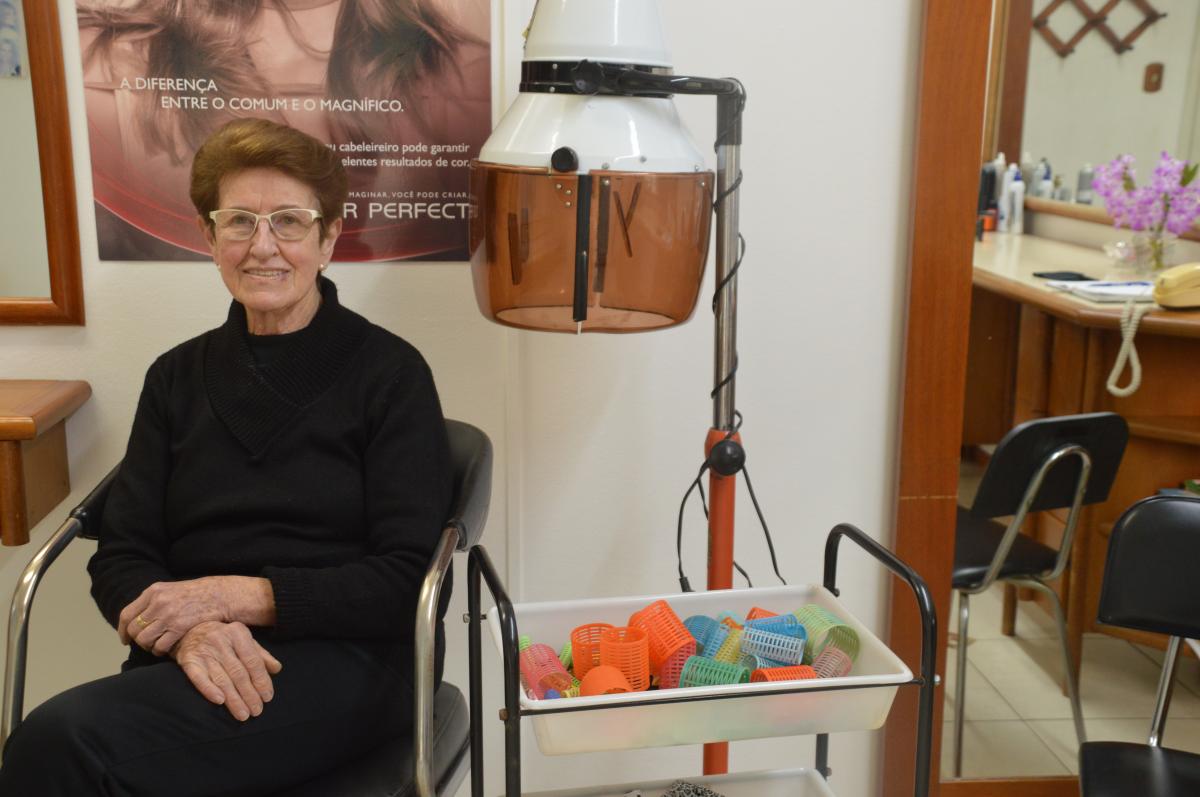 A cabeleireira com os bobs e o secador de cabelo antigo A cabeleireira com os bobs e o secador de cabelo antigo