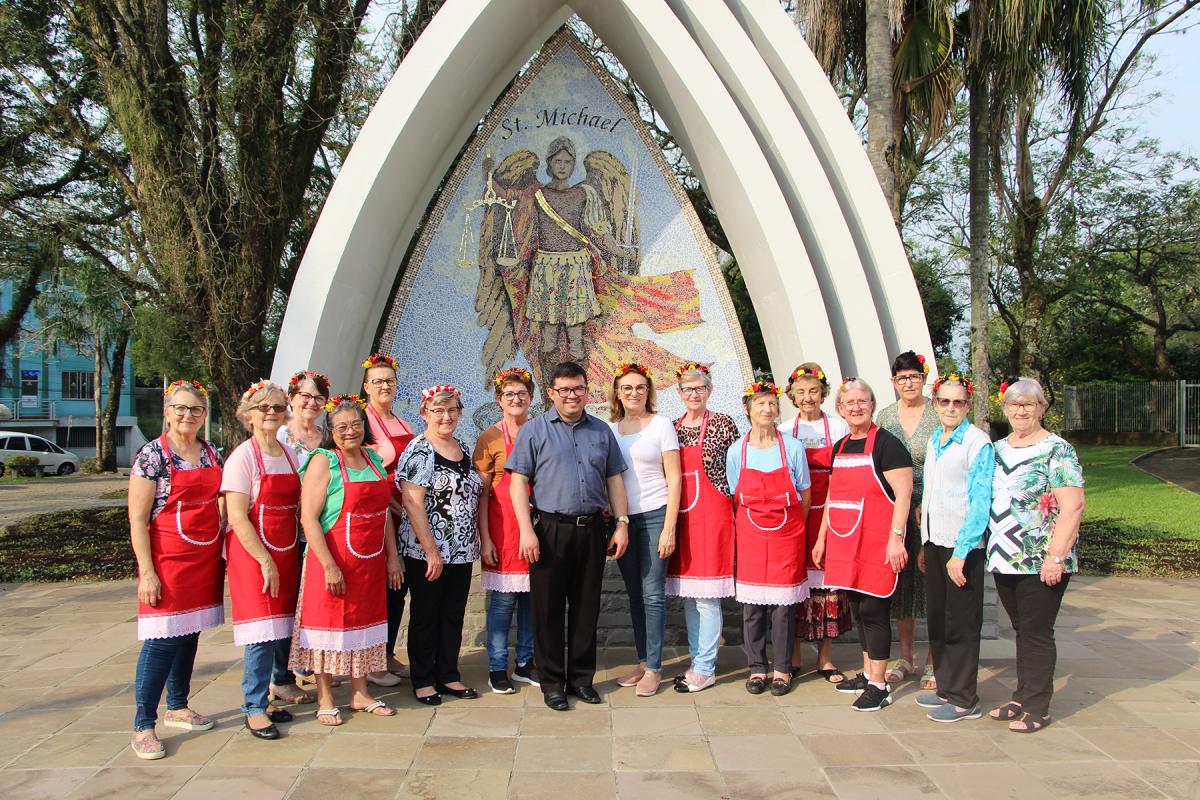 Miguelinas com o Pe. Alexsandro Lemos da Silva em frente ao monumento do Arcanjo São Miguel