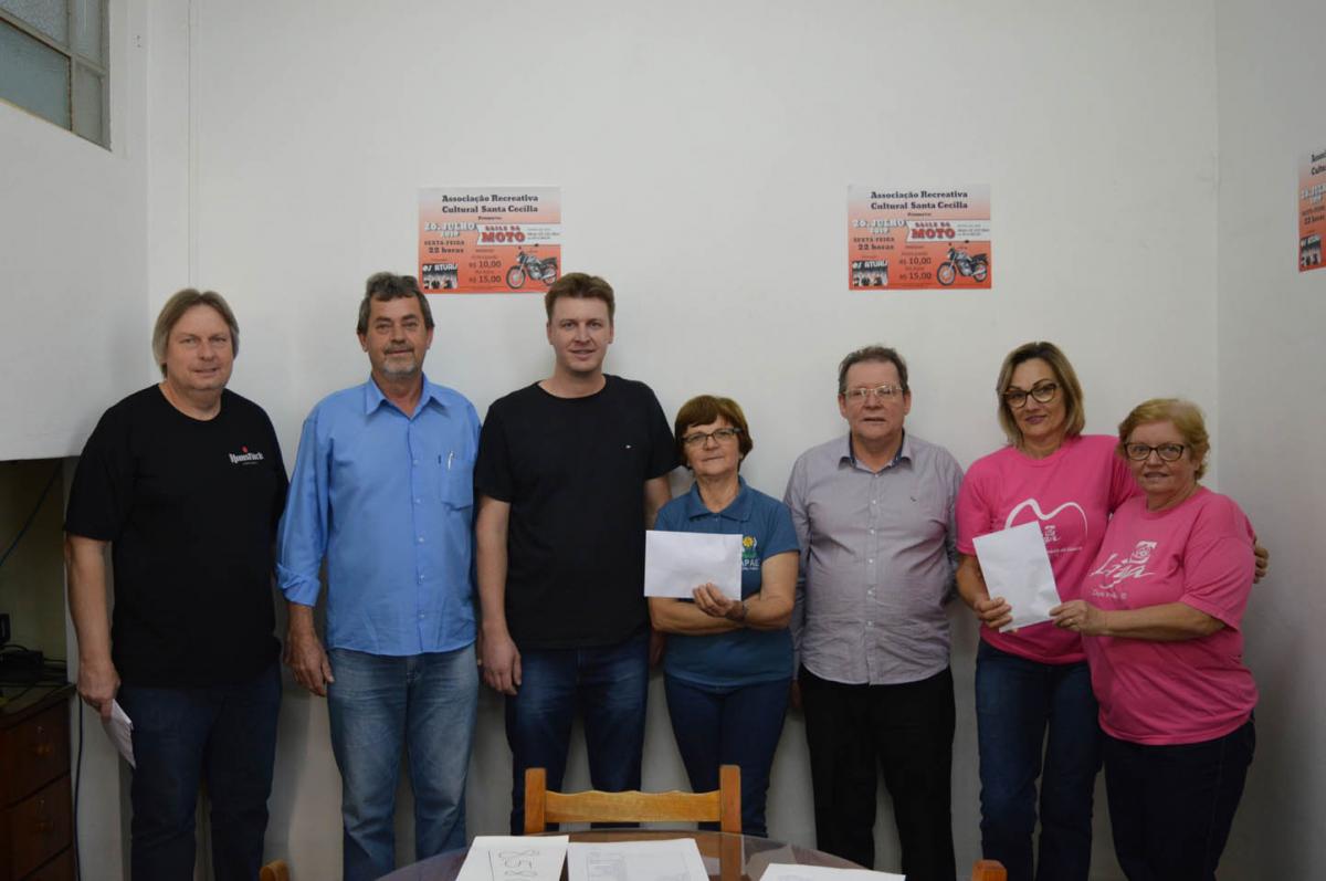 Miguel (ganhador da moto), Protásio (presidente da Santa Cecília), Ismael (tesoureiro),  Leoni (APAE), Alceu (vice-presidente), Cláudia e Vinilda (Liga Feminina)