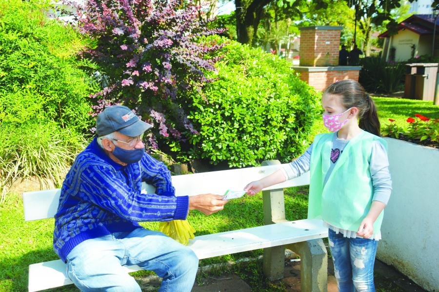 Alunos entregam cartões para conscientizar adultos sobre a importância de cuidar da natureza