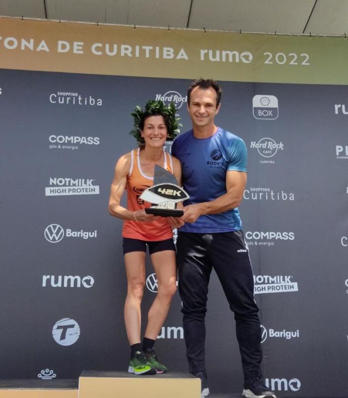 Marlei com o troféu no pódio ao lado do treinador Júlio Pauletti