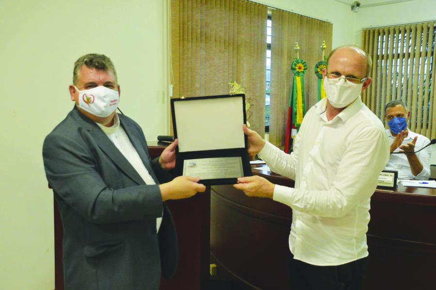 Padre Dirceu recebe a placa do vereador Darlei