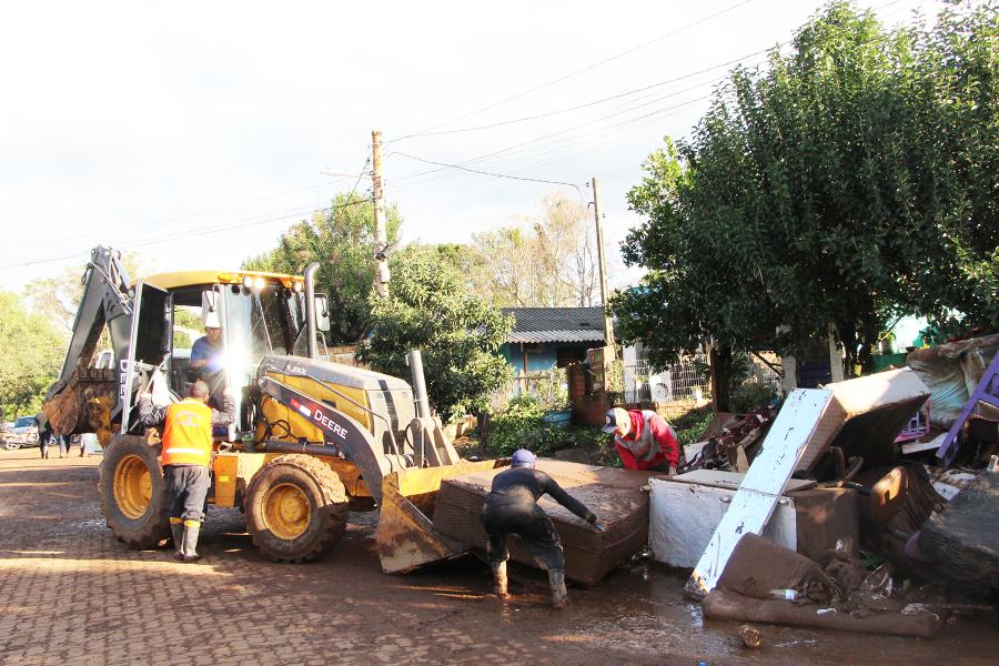 Retroescavadeira recolhendo móveis e utensílios no bairro Portal da Serra