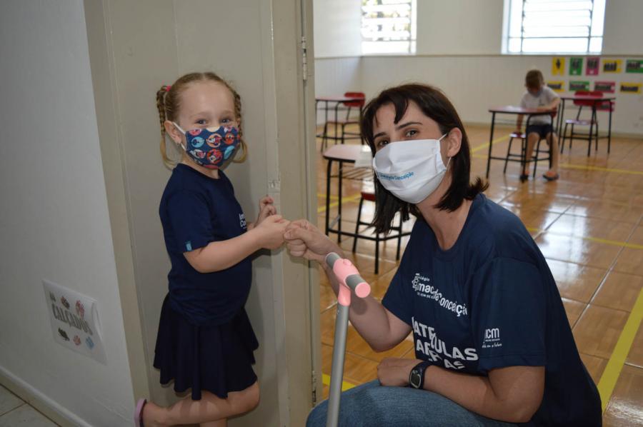 Sem a possibilidade de abraços, a pequena Maria Antônia, do Pré - Nível 1A cumprimentou a professora Monisie de um jeito diferente