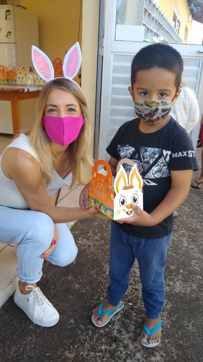 Voluntária Amanda ajudando na distribuição dos ninhos às crianças